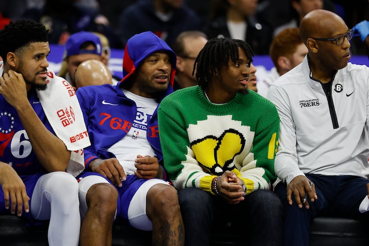 Sixers guard Tyrese Maxey (second from right) sits with assistant coach Sam Cassell and teammates P.J. Tucker (left) and Tobias Harris during the game against the Atlanta Hawks on Monday.