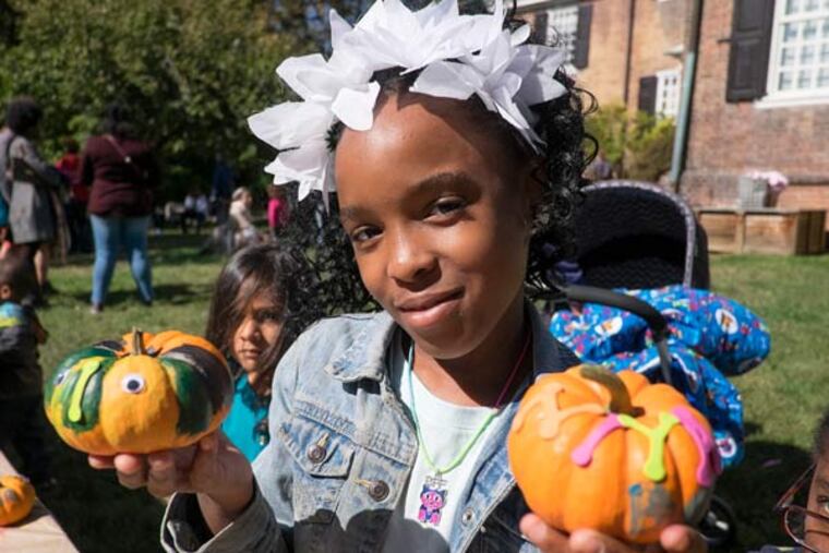 The venerable Wofford Mansion in Fairmount Park holds its annual Apple Festival featuring games,crafts and of course apples. Here, 9 year old Iniya Saunders-Thompson shows off her decorated pumpkins. (ED HILLE / Staff Photographer)