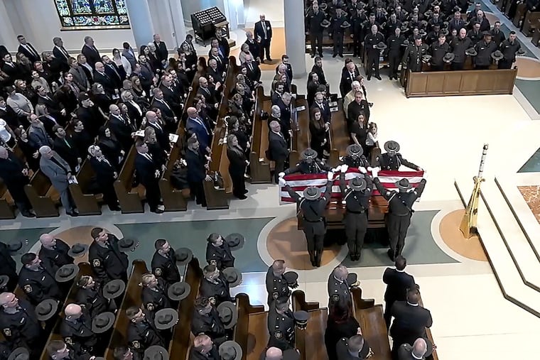 Pennsylvania state troopers fold the flag that covered the casket of Cpl. Timothy O’Connor Jr. during his funeral service at St. Joseph Church, in Downingtown on Wednesday.