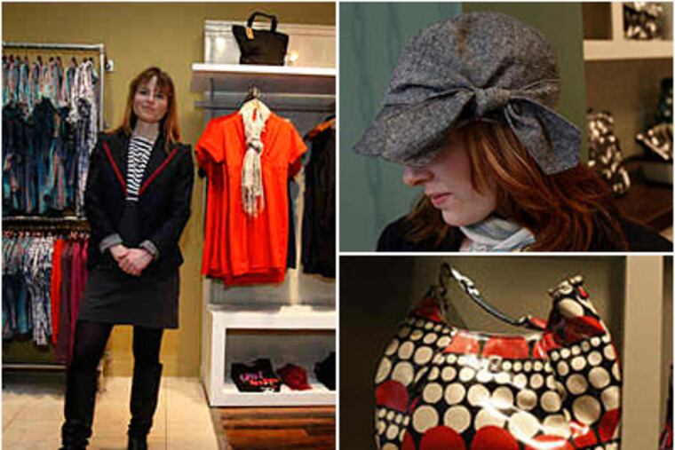 Lexy Funk (left) visits her Brooklyn Industries (left) store on Walnut Street. The shop features a polka-dotty bag (right) and a side-tie hat, modeled here by assistant manager Melissa Yerkes. (Michael S. Wirtz / Staff)