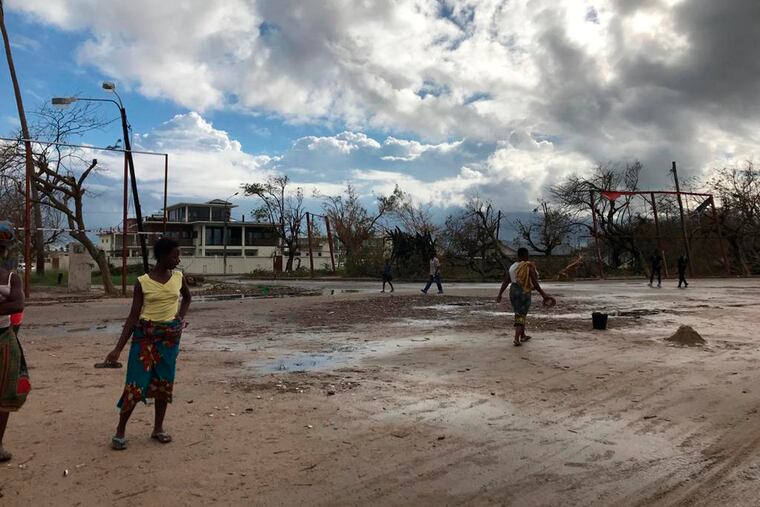 People go on their morning errands amid the shattered city of Beira, Friday, March 22 2019. Some hundreds of people are dead, many more still missing and with many thousands at risk from massive flooding in Mozambique, Malawi and Zimbabwe caused by Cyclone Idai.