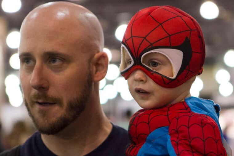 Griffin O'Donnell is dressed as a tiny Spider-Man while his father, Todd, takes him around.