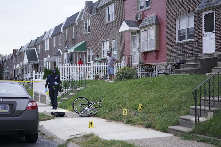 Investigators look for evidence near the victim’s bicycle on Magee Avenue near Bustleton Avenue, Wednesday, Oct. 11, 2017, in Oxford Circle, after police saw a teen shoot another teen in the head. The victim was listed in critical condition.