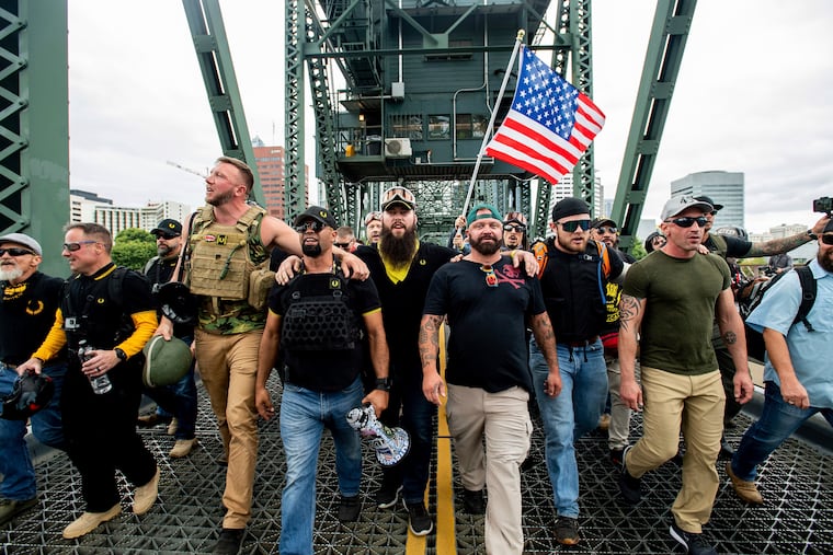 In this Aug. 17, 2019 file photo, members of the Proud Boys and other right-wing demonstrators march across the Hawthorne Bridge during an "End Domestic Terrorism" rally in Portland, Ore.