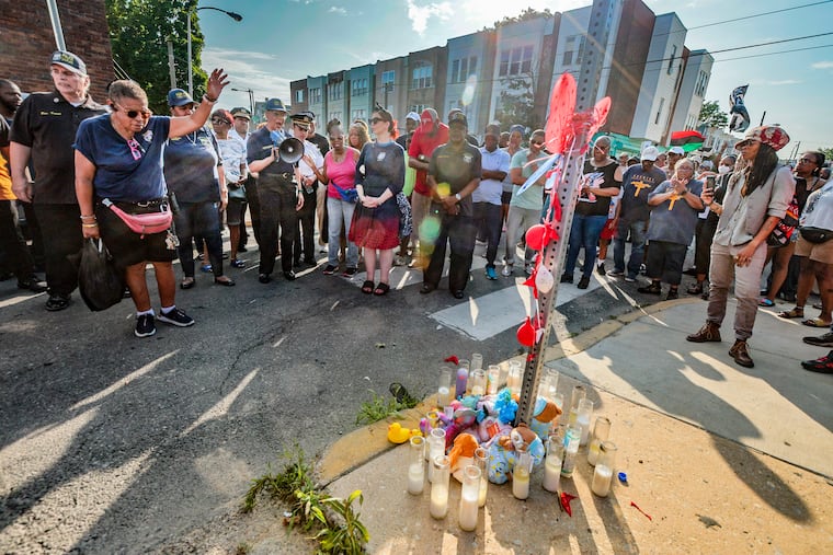 Philadelphia Police Department 12th District and community members stop for a prayer at Chester Avenue and Fraizer Street during an anti-violence prayer walk in the wake of the Kingsessing mass shooting.
