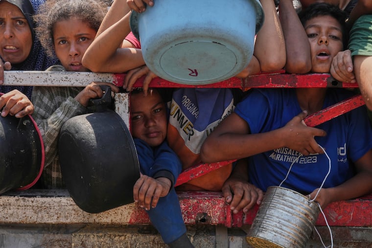 Palestinians struggle to get donated food at a community kitchen in Gaza City, northern Gaza Strip, on Saturday.