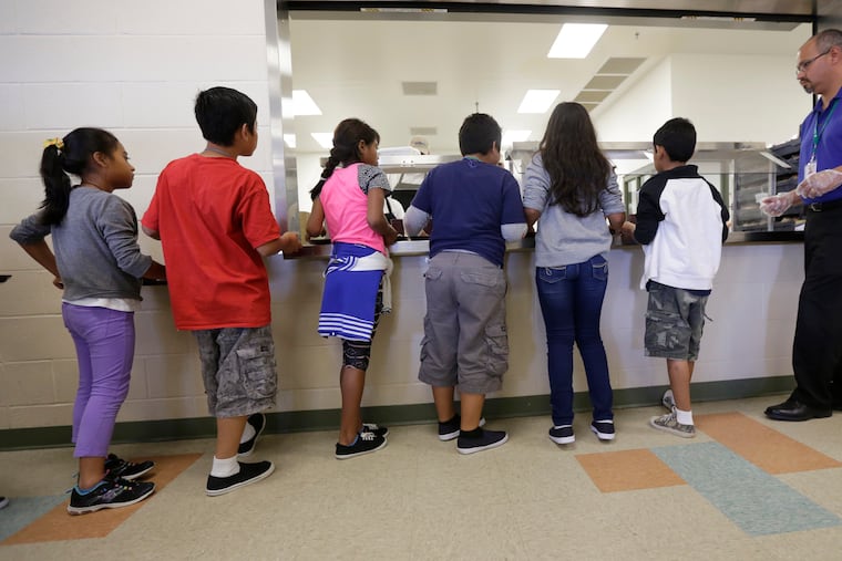 Detained immigrant children line up for food in the cafeteria at a detention center in Texas. For-profit companies already make money on such centers. Now they want to profit from children's legal support, write Jim Sandman and Michael Lukens.