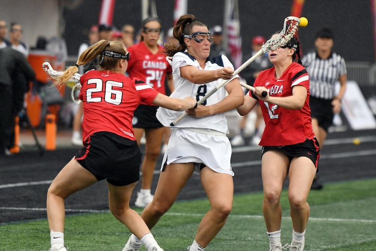 The United States' Alice Mercer (8) is pressured by Canada midfielders Raegan Wilson (26) and Megan Kinna (12) in the first half during the World Lacrosse Women's World Championship at Towson University's Johnny Unitas Stadium on Saturday.