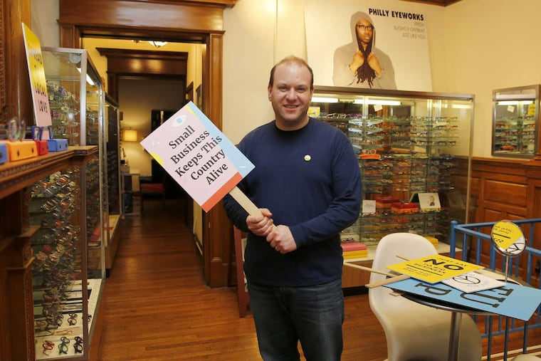 Innervision Eyewear owner Clifton Balter stands in his Center City 2nd floor showroom with a sign promoting small local business on Wednesday, January 25, 2017.