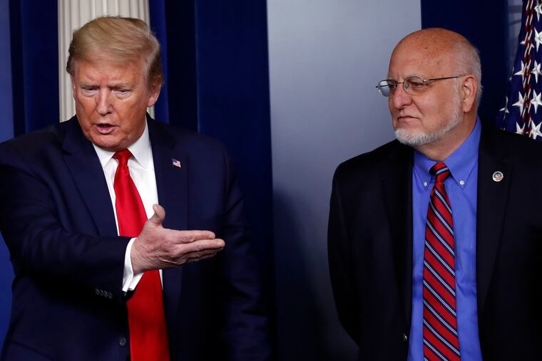 President Donald Trump speaks about the coronavirus as Dr. Robert Redfield, director of the Centers for Disease Control and Prevention, listens.