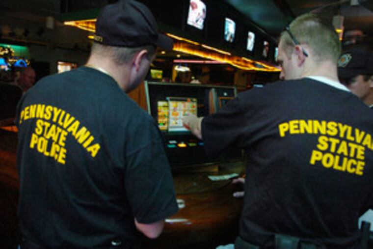 State police officers check out a video slot machine called Fruit Bonus 2000 inside Della Polla's. The raid was part of a statewide effort to crack down on illegal slots gambling.