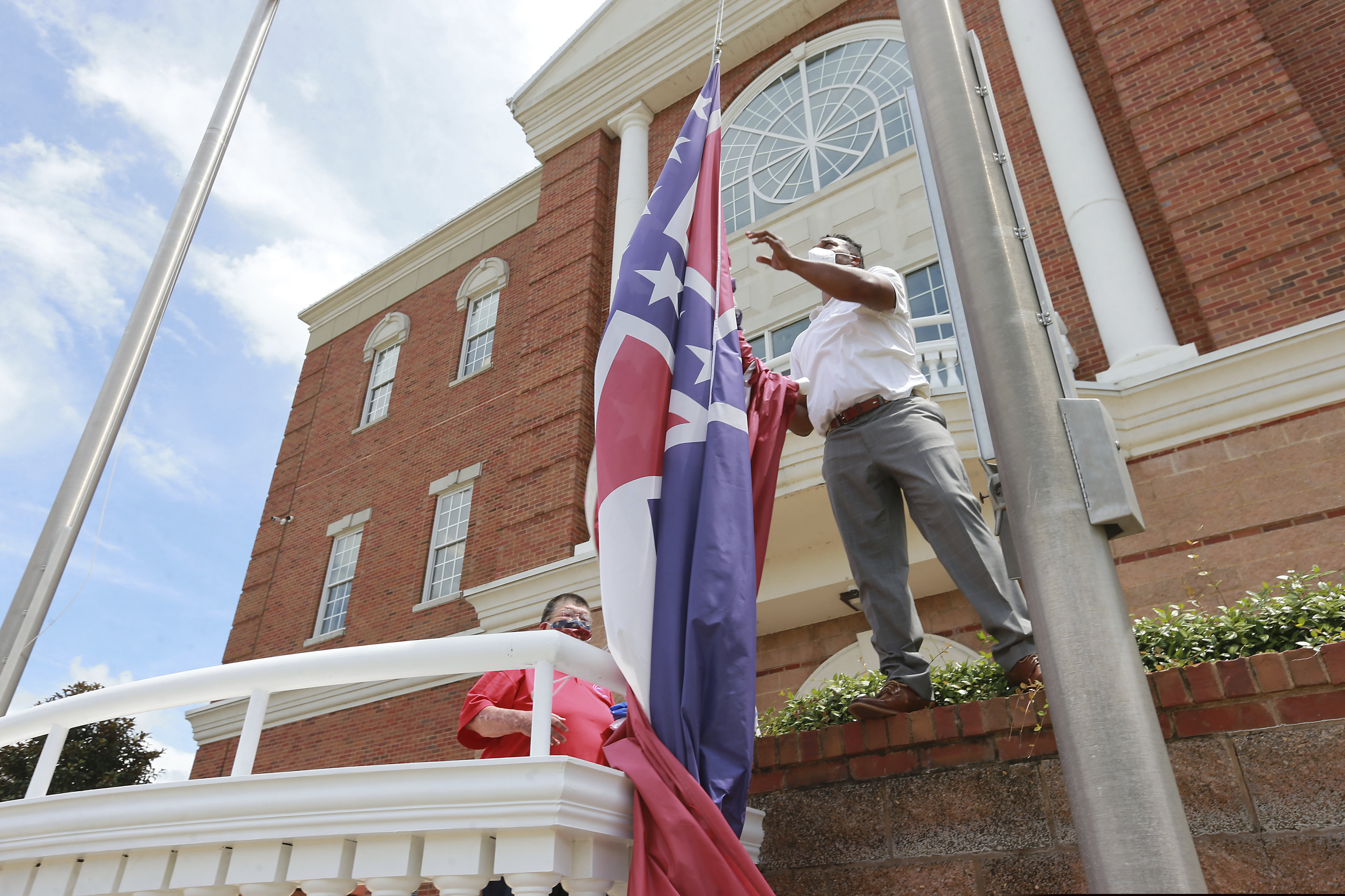 City of Tupelo Community Outreach Coordinator Marcus Gary takes down the State Flag of Mississippi that flew over the City Hall of Tupelo one last time Monday, June 29, 2020. Mississippi is retiring the last state flag in the U.S. that includes the Confederate battle emblem.