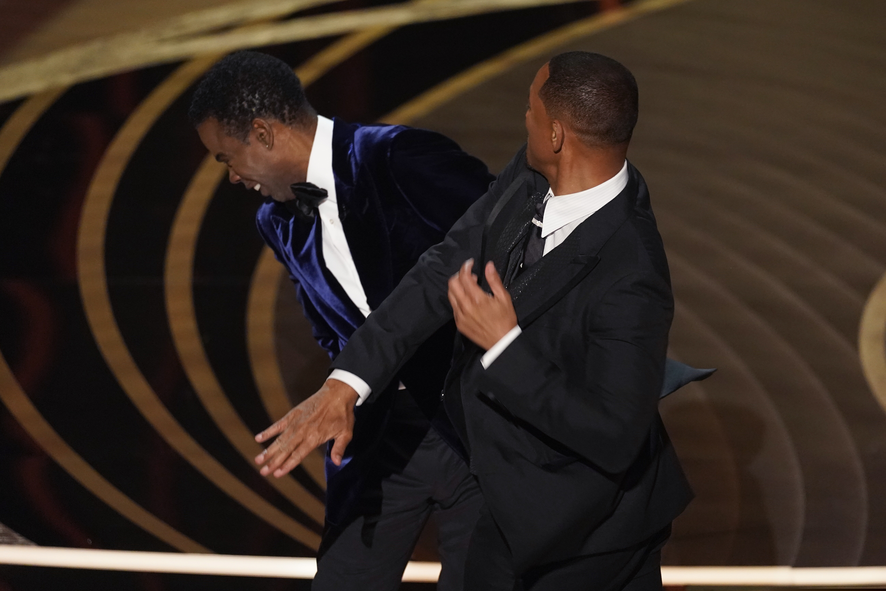 Will Smith, right, hits presenter Chris Rock on stage while presenting the award for best documentary feature at the Oscars on Sunday at the Dolby Theatre in Los Angeles.