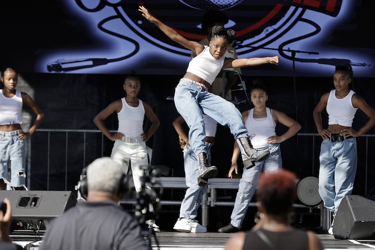 Kierce Reily Johnson Gray, 10, of Phila. (center) leaps in the air while performing with the group Mega Modelz Xexpressionz during the 20th Anniversary Give Back Community Festival and Concert at Nicetown Park, 4301 Germantown Ave. Phila., Pa. on Aug. 12, 2022.