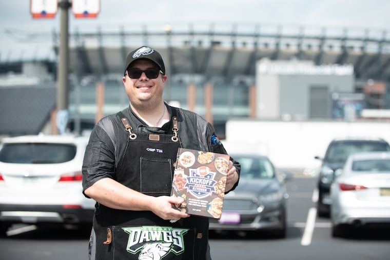 Former Eagles chef and South Jersey native Tim Lopez poses for a portrait with his football-themed cookbook, “Kickoff Kitchen,” at his tailgate event outside of Lincoln Financial Field on Saturday.