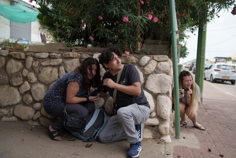 Israelis take cover from incoming rocket fire from the Gaza Strip in Ashkelon, southern Israel, on Oct. 11, 2023.