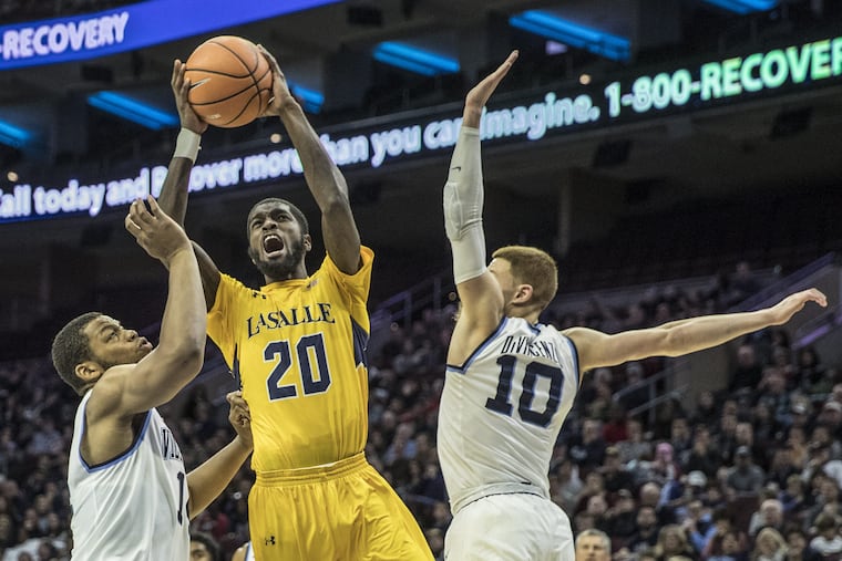 La Salle's B.J. Johnson tries to put up a shot between Villanova's Omari Spellman (left) and Donte DiVincenzo during last year's La Salle-Villanova matchup. This year the game will be held (without these three players) at the Palestra in December.