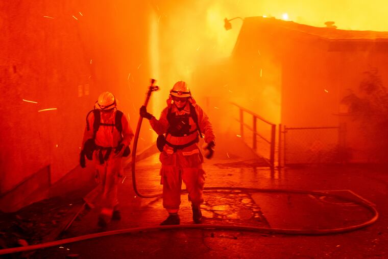 FILE - In this Thursday, Nov. 8, 2018 file photo, firefighters battle the Camp Fire as it tears through Paradise, Calif. A report on firefighter injuries in a deadly Northern California wildfire details harrowing conditions they faced and a few close calls with death. The report released Thursday, Dec. 13, 2018 by the California Department of Forestry and Fire Protection said the Camp Fire overtook three firefighters trying to set a backfire Nov. 8 to stop the blaze. (AP Photo/Noah Berger, File)