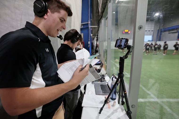 Rowan students broadcaster Keegan Thompson (left) and Dylan Corsi check the lineups before a Greater Philadelphia Collegiate Box Lacrosse League game on July 17.