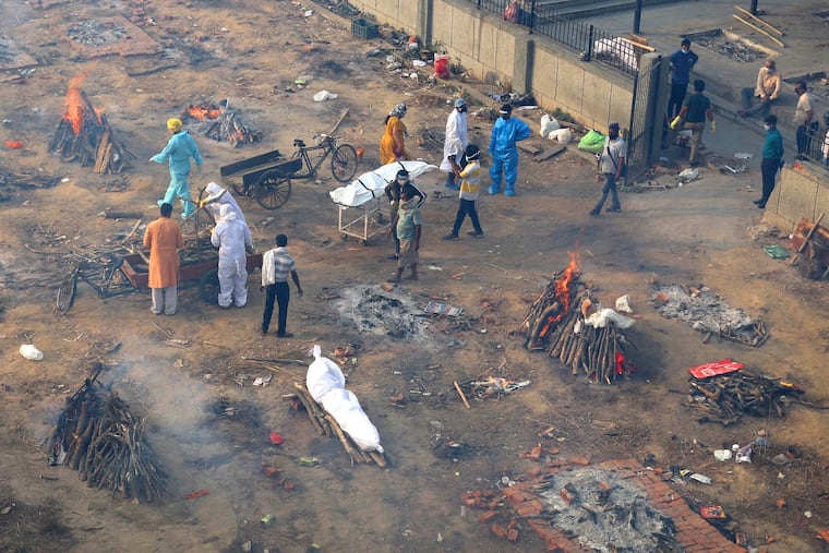 Multiple funeral pyres of those patients who died of the Covid-19 coronavirus disease are seen burning at a ground converted into a makeshift crematorium where mass cremation of covid deaths are held, in New Delhi, India, Wednesday , April 21, 2021.