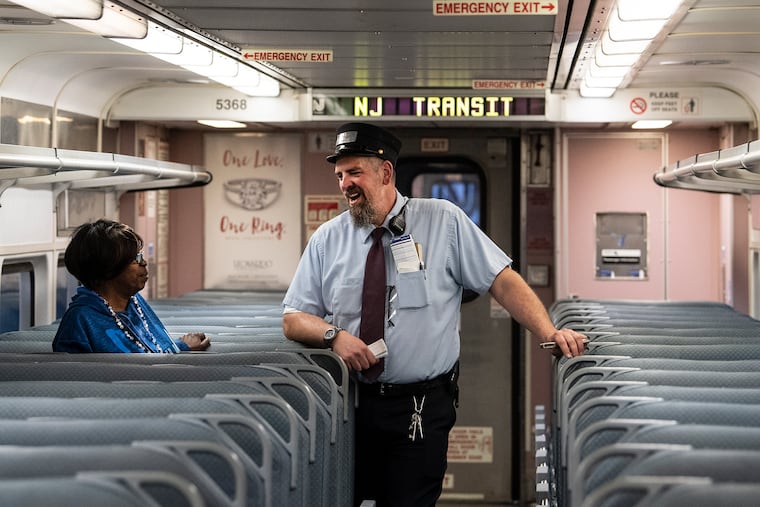 NJ Transit assistant train conductor Tom Coupe talks with a passenger on the way to Atlantic City in May 2019.