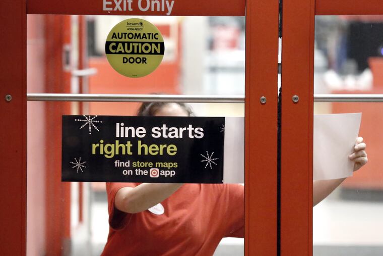 At the Deptford Target, Tina Pinto posts a sign on the front door, preparing for last year's Thanksgiving crush.