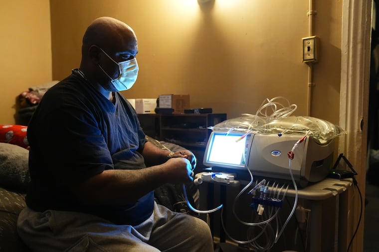 Ahmad Collins, a city government worker and former Penn State linebacker, prepares for his nightly dialysis treatment at his home in Harrisburg.