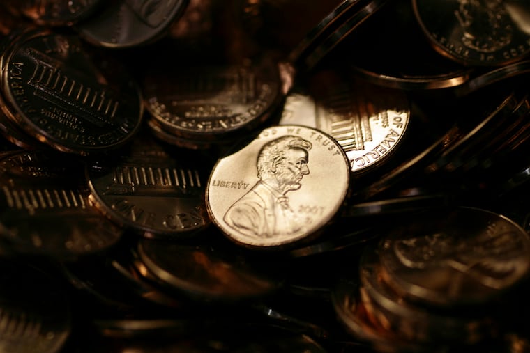 A lone penny is illuminated in a bin of completed pennies at the U.S. Mint in Denver.