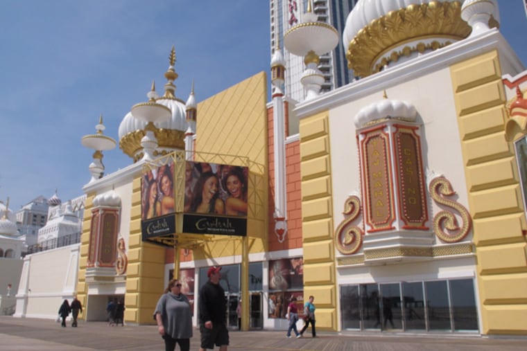 Pedestrians on the Atlantic City N.J. boardwalk look up at the newly renovated facade of the Trump Taj Mahal Casino Resort on Monday, April 8, 2013. Atlantic City tourism officials unveiled a new $20 million advertising campaign on Tuesday, April 9, 2013, designed to bring more visitors to the seaside gambling resort. (AP Photo/Wayne Parry)