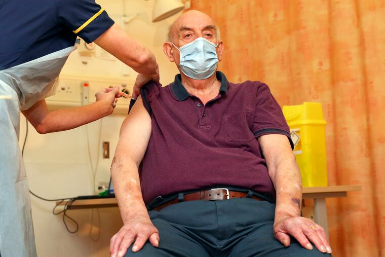 82-year-old Brian Pinker receives the Oxford University/AstraZeneca COVID-19 vaccine from nurse Sam Foster at the Churchill Hospital in Oxford, England, on Monday.