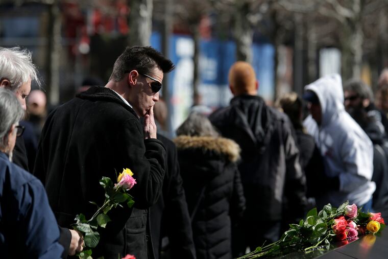 People place flowers over the names of the victims of the 1993 World Trade Center bombing during a ceremony at the 9/11 Memorial in New York, Tuesday, Feb. 26, 2019. (AP Photo/Seth Wenig)