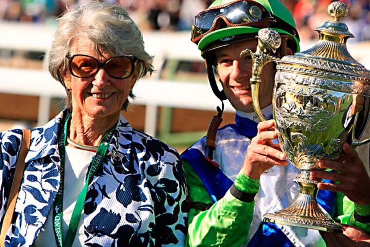 Owner and breeder Gretchen Jackson, left, stands with jockey Julien Leparoux, who hoists the trophy after Divining Rod won the Lexington Stakes horse race at Keeneland in Lexington, Ky., Saturday, April 11, 2015. (Garry Jones/AP)