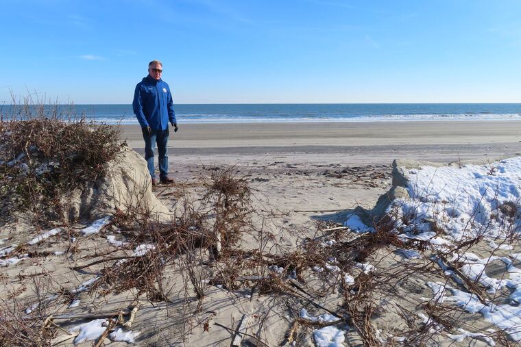 Mayor Patrick Rosenello stands next to a destroyed section of sand dune in North Wildwood on Jan. 22. A recent winter storm punched a hole through what is left of the city's eroded dune system, leaving it more vulnerable than ever to destructive flooding as the city and state fight in court over how best to protect the popular beach resort.