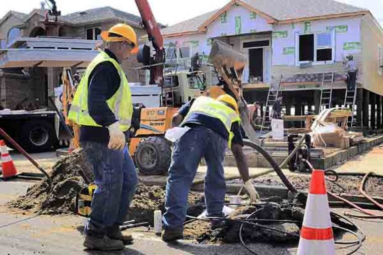 New Jersey Natural Gas workers (no ID's) work on installing new service to a home under construction in Point Pleasant Beach April 9, 2013, where the homeowner tore down his house after it was damaged by Hurricane Sandy, and built new. ( TOM GRALISH / Staff Photographer )