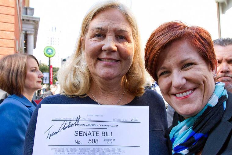 Maureen Faulkner, left, widow of police officer Daniel Faulkner, holds a signed copy of Senate Bill 508 alongside of Pennsylvania Victim Advocate Jennifer Storm after Pennsylvania Gov. Tom Corbett signed the bill titled the Re-victimization Relief Act, Tuesday Oct. 21, 2014 in Philadelphia. Corbett signed into law the measure he says is intended to curb the "obscene celebrity" he says is cultivated by convicts like Mumia Abu-Jamal, who is serving a life sentence for the 1981 killing of Daniel Faulkner. (AP Photo/The Philadelphia Inquirer, David M. Warren) PHIX OUT; TV OUT; MAGS OUT; NEWARK OUT