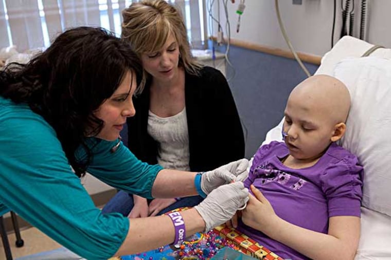 Emily Whitehead, 7, of Philipsburg, Pa., getting an infusion of the gene therapy from nurse Colleen Wallace as her mother, Kari, watches at Children’s Hospital in 2012. She was one of 22 children who participated in the study, and now the third grader takes gifts and encouragement to other children there.