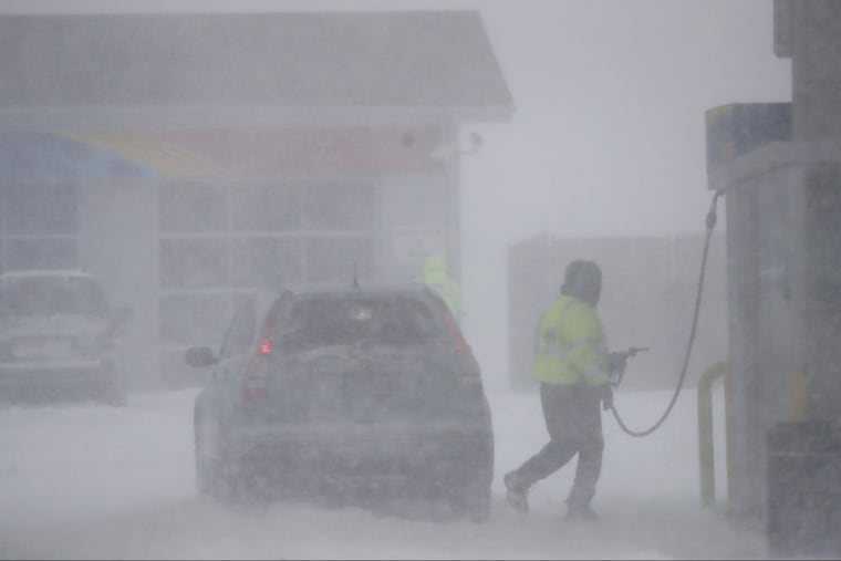 A gas station employee finishes pumping gas on a vehicle at the Monmouth Service Station along the Garden State Parkway during a snowstorm, Thursday, Jan. 4, 2018, in Wall Township, N.J.
