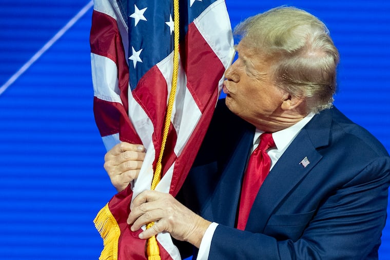 Republican presidential candidate former President Donald Trump kisses the flag as arrives to speak during the Conservative Political Action Conference, CPAC 2024, at National Harbor, in Oxon Hill, Md., on Feb. 24.