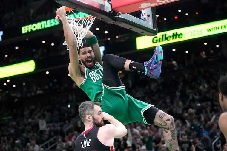 Boston Celtics forward Jayson Tatum, top, dunks as Miami Heat forward Kevin Love defends during the first half in Game 5 of the NBA basketball Eastern Conference finals series Thursday, May 25, 2023, in Boston. (AP Photo/Charles Krupa )