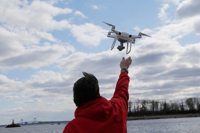 A drone operator helps to retrieve a drone after photographing over Hart Island in New York. Much larger unidentified drones have been spotted flying over New Jersey.