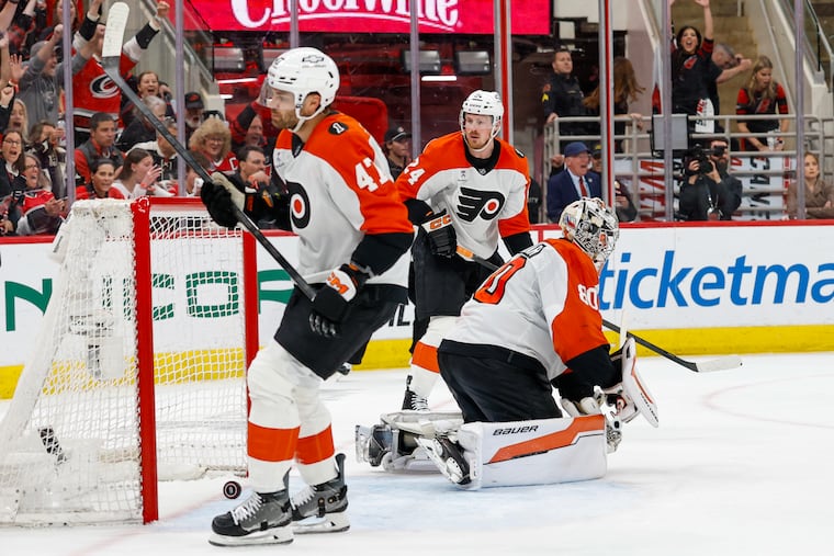 Flyers goaltender Dan Vladar (center), Noah Juulsen (left) and Nick Seeler are shown after a Hurricanes second period goal on Saturday.