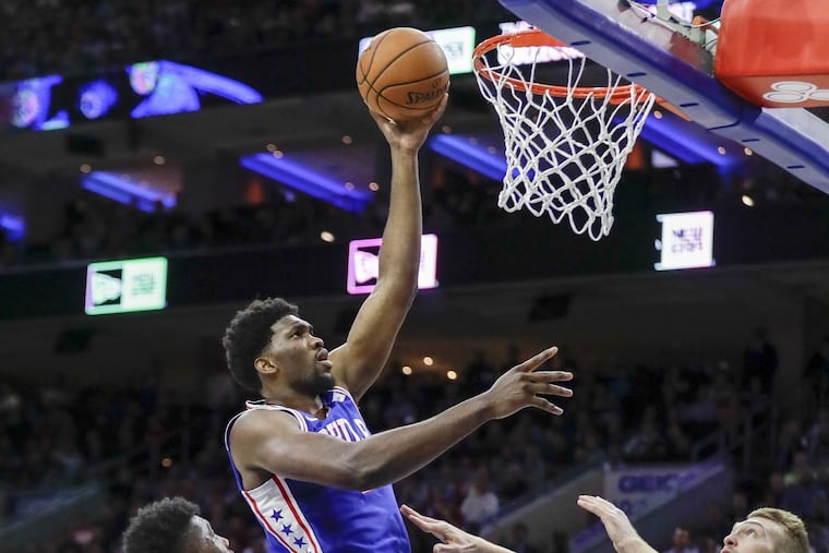 Sixers center Joel Embiid lays-up the basketball against Indiana Pacers forward Thaddeus Young (left) and Indiana center Domantas Sabonis on Friday, November 3, 2017 in Philadelphia. YONG KIM / Staff Photographer
