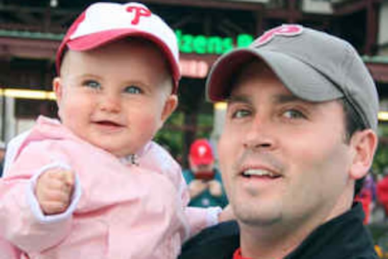 Gearing up for Game 1 of the Series, Brian McCollum and daughter Sarah Carmel, 1, of Delaware County, take in an Irish Night game at Citizens Bank Park.