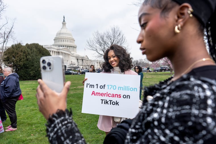 Devotees of TikTok, Mona Swain, center, and her sister, Rachel Swain, right, both of Atlanta, monitor voting at the Capitol in Washington on Wednesday as the House passed a bill that would lead to a nationwide ban of the popular video app if its China-based owner doesn't sell.