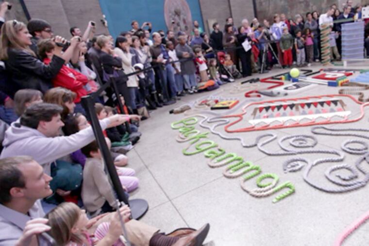 Spectators delight over a four-minute display of 10,000 dominoes toppling at the University of Pennsylvania Museum of Archaeology and Anthropology. (Caitlin Morris / Staff Photographer)