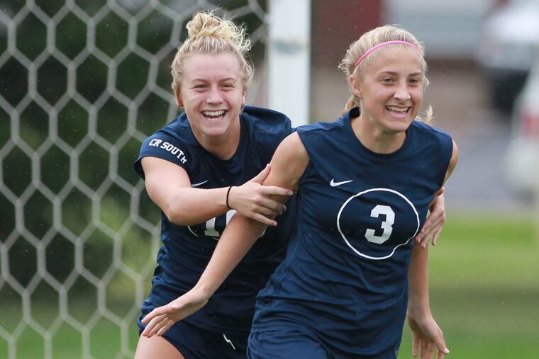Julie Rebh, right, of Council Rock South is congratulated by teammate Paige Mikula, center, after scoring a goal against Pennsbury.
