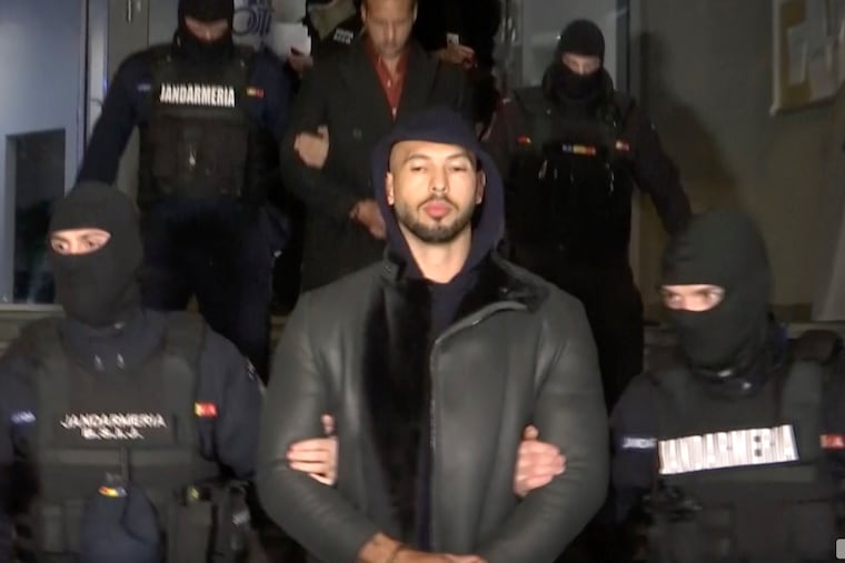 In this grab taken from video released by Observator Antena 1, Social Media personality Andrew Tate is led away by police in Romania.