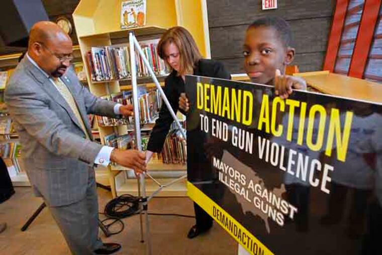 Philadelphia Mayor Michael Nutter with the assistance of Kevin Dudley, 10, of north Philadelphia replace a sign displayed during the mayor press conference on gun violence. Philadelphia Mayor Michael Nutter held a press conference at the Widener Branch Library at 28th and Lehigh Ave on Thursday afternoon March 29, 2013. Mayor Nutter spoke on behalf of Mayors Against Illegal Guns, part of National Day to Demand Action to end gun violence. ( ALEJANDRO A. ALVAREZ / STAFF PHOTOGRAPHER )