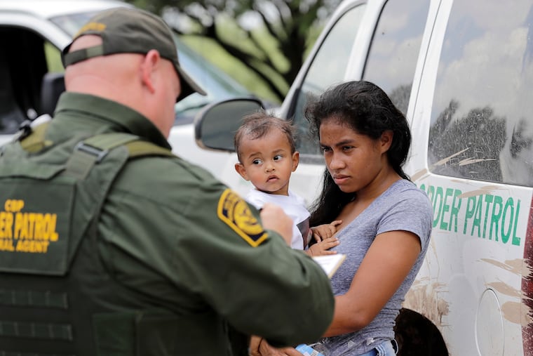 In this June 25, 2018, file photo, a mother migrating from Honduras holds her 1-year-old child as surrendering to U.S. Border Patrol agents after illegally crossing the border near McAllen, Texas. The Trump administration says it would require extraordinary effort to reunite what may be thousands of migrant children who have been separated from their parents and, even if it could, the children would likely be emotionally harmed. (AP Photo/David J. Phillip)