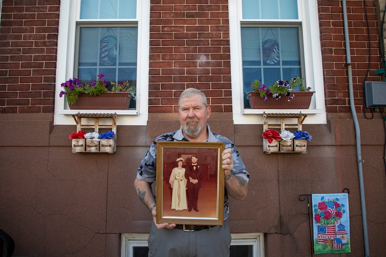 Tom Callen, 70, of Fishtown, retired stationary engineer school district of Philadelphia, holds a picture frame of him and his wife, Carol, Callen 79, on their wedding day out in the front of his home on Thursday, August 1, 2019. Tom was married to his wife, Carol Callen, 79, for almost 40 years, but had passed four days before their 40th anniversary. Tom had started to grow his garden of flowers and wanted to move his flowers to the front of their home, but Carol never wanted it to happen. "This is really dedicated to her, the flowers," Callen said. "I feel like I got part of her back again."